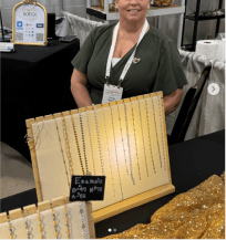 Design placeholder: Tracey at a Crescent Rouge pop-up with the chain display. Direction reference only, not a cleared production photograph.